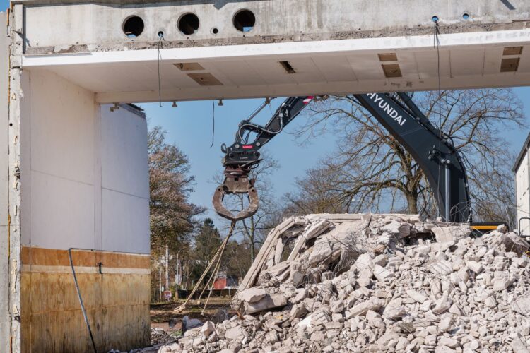 Bagger mit Greifarm beim Abriss einer Industriehalle