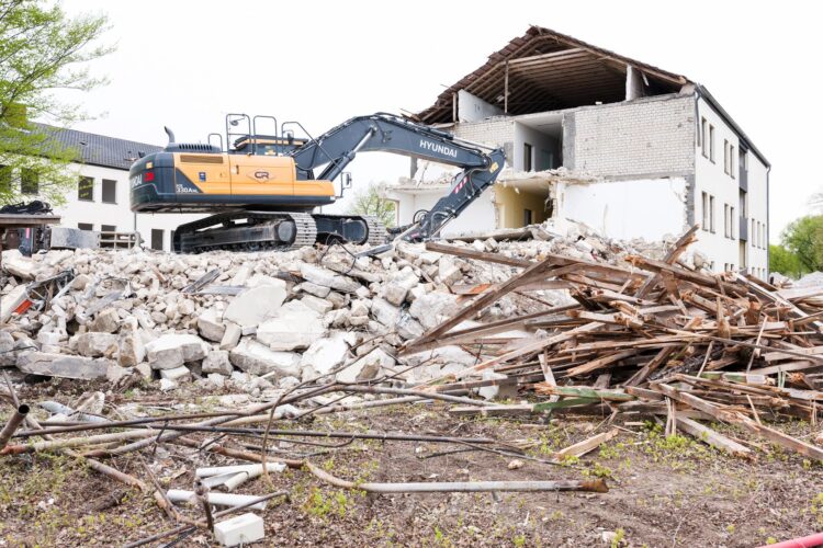 Bagger beim Abriss eines Gebäudes mit Schutt und Trümmern