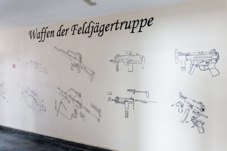Wand mit Zeichnungen von Waffen und der Beschriftung Waffen der Feldjägertruppe