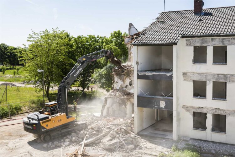 Bagger reißt ein Gebäude ab