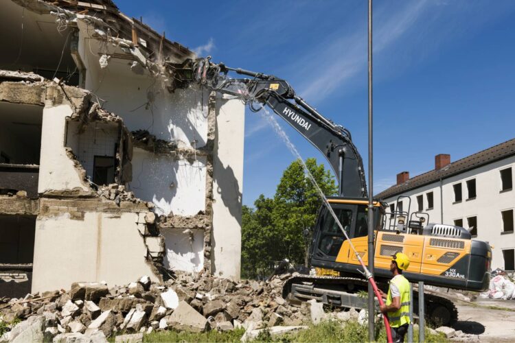 Bagger bei Abrissarbeiten an einem Gebäude